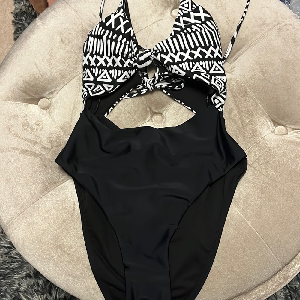 Black and white one piece swim suit w cutouts in front & back, adjustable straps